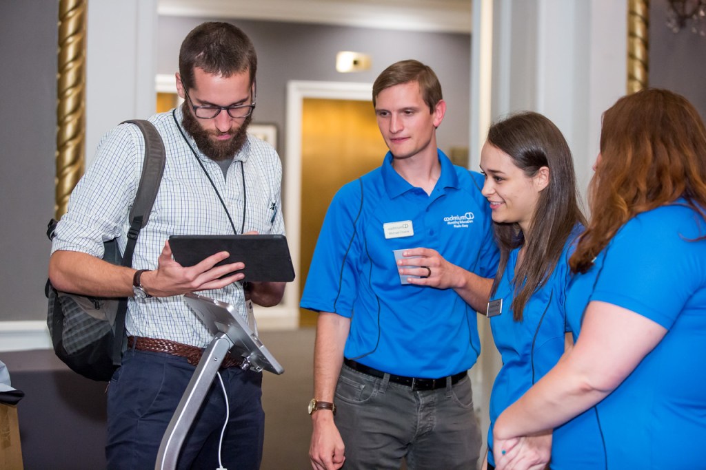 CadmiumCD's Michael Doane, Rachel Vrankin, and Rachel Schmidt, talking with CadmiumCD customer, Preston Reeves of NAFSA, about new event tech.