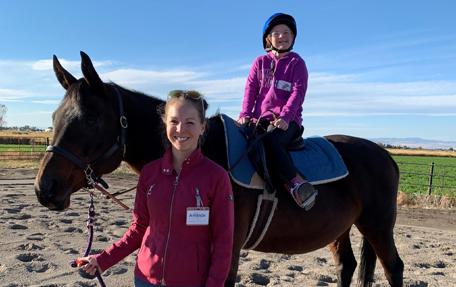 I started working within the Equine Therapeutic Riding Program at Eagle Mount the summer of 2018. I have been involved with the equine industry my entire life, but this was my first experience working within the therapy sector. I assist as a horse leader to ensure that the horse responds appropriately when the rider is working on their skills. I also get to interact with students while helping with grooming and tacking, as well as any pick up help around the barn.