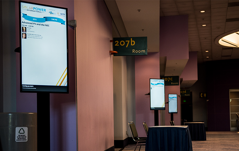 Digital room signage features presentation information, speaker headshots and biographies, and a section that alerts attendees about upcoming sessions at your conference.