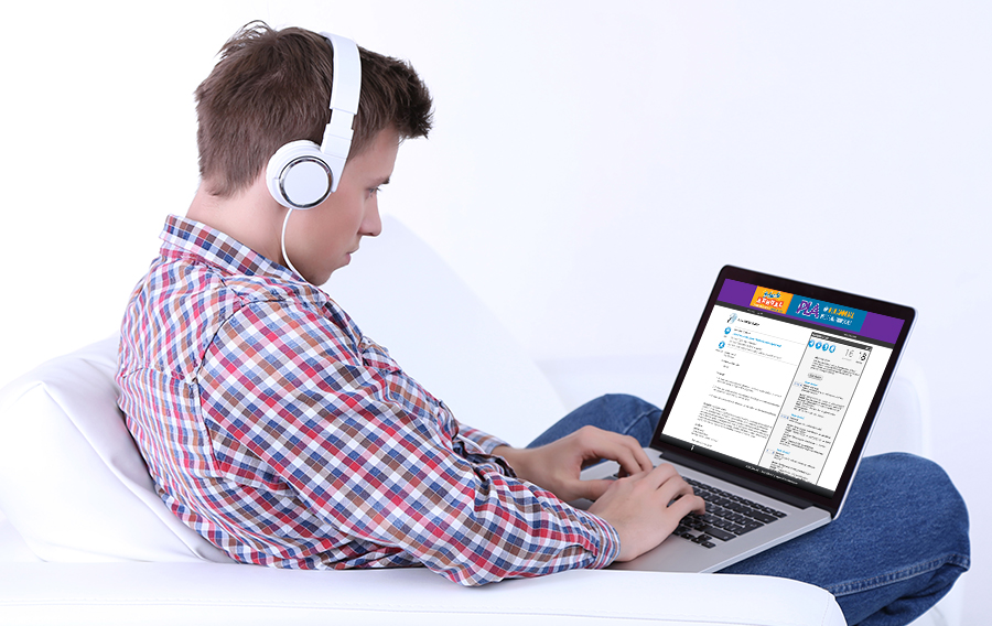 A man in a flannel shirt with headphones on uses the Abstract Scorecard to submit a call for papers proposal via his laptop.