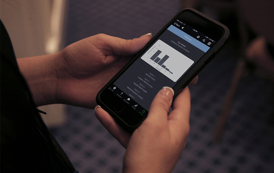 An attendee sees the results of a poll pop up on her iPhone screen.
