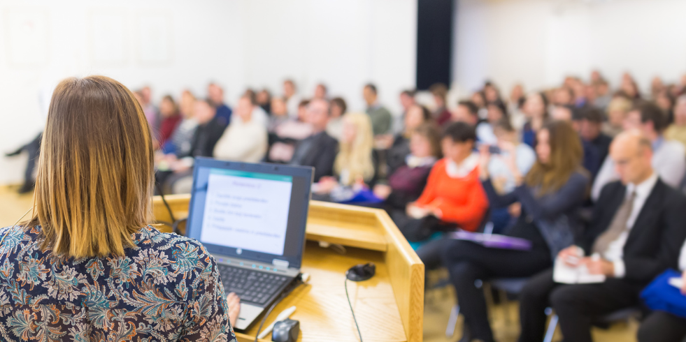 Speaker giving a presentation at an in-person event.